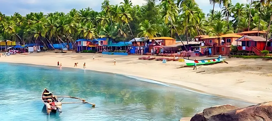 Palolem Beach: A vibrant beach scene featuring colorful houses and boats lining the sandy shore under a clear blue sky.