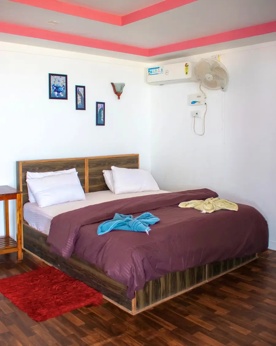 A neatly made bed in the Double Seafacing Hut room, featuring soft linens and a warm ambiance.