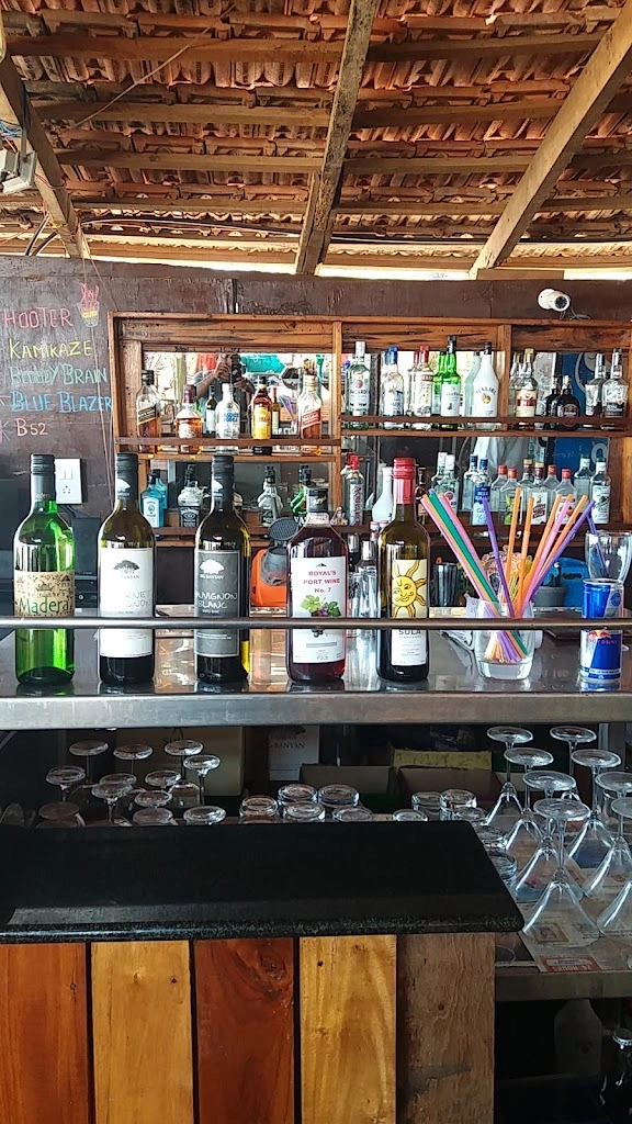 A bar scene displaying numerous bottles of alcohol and various drinks, highlighting a diverse assortment of beverages.