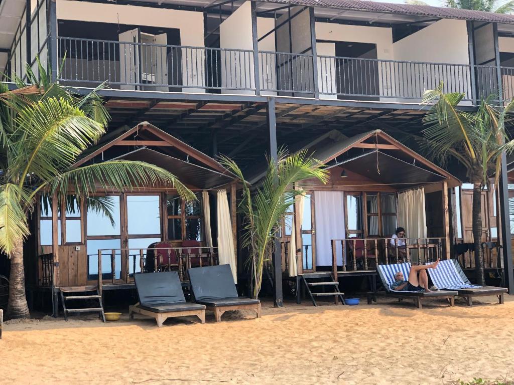  A picturesque beach huts with two inviting balconies and a comfortable lounge chair, perfect for relaxation.