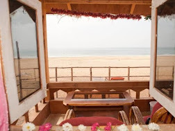  A serene beach view framed by the wooden structure of a cozy house, showcasing sand and waves in the distance.