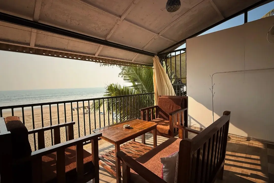 A serene balcony overlooking a picturesque beach and the vast ocean, inviting relaxation and tranquility.