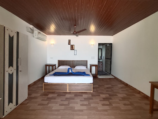 A cozy bedroom featuring wooden floors and a ceiling fan, creating a warm and inviting atmosphere.